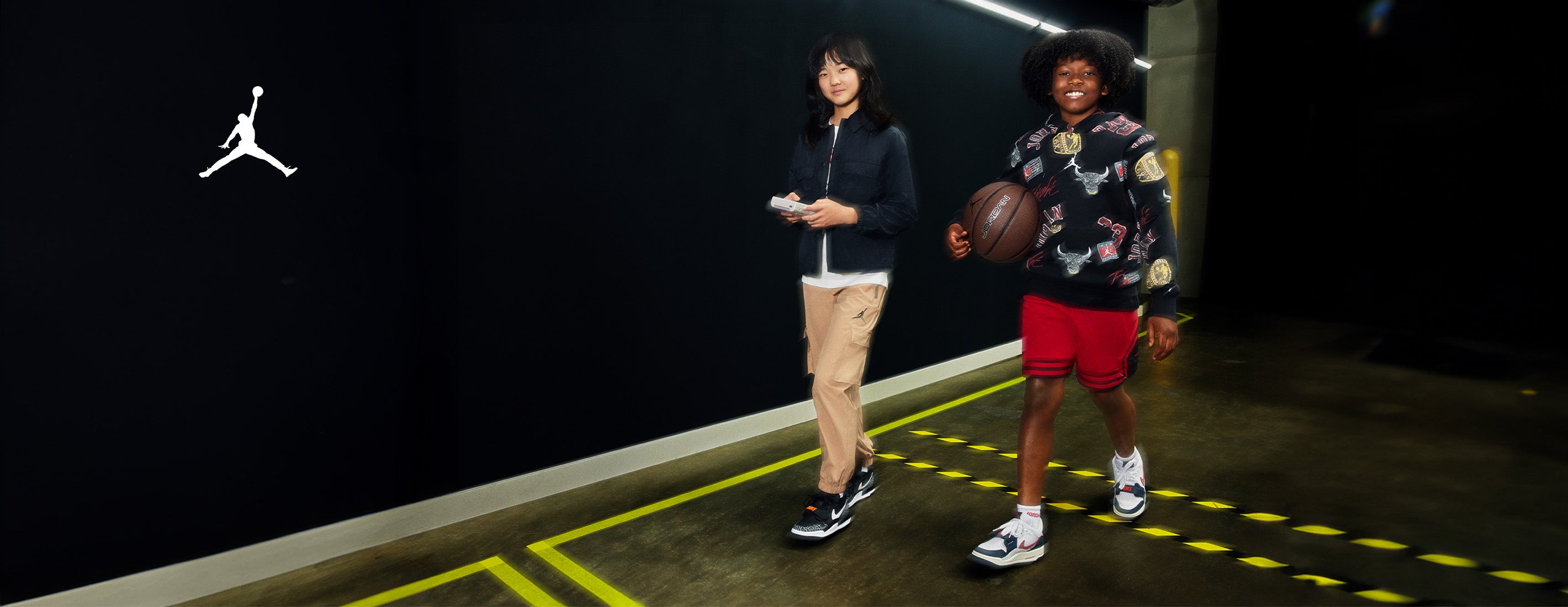 kids walking with a basketball wearing branded Jordan gear 